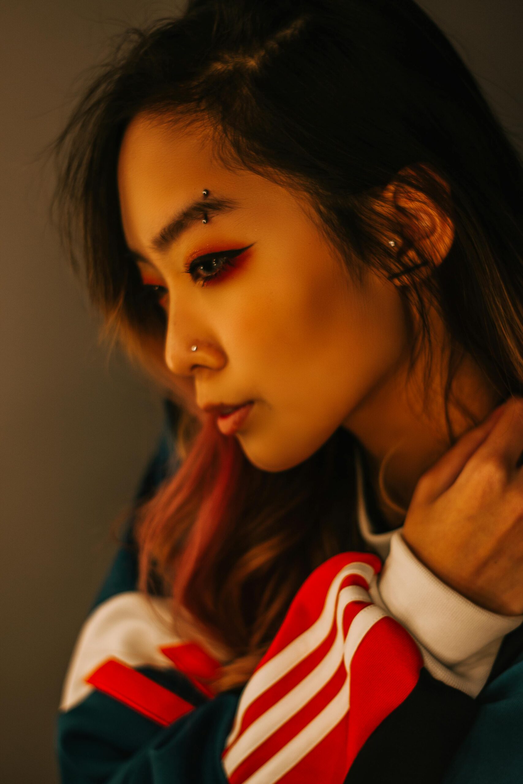 Profile portrait of a fashionable young woman with bold eye makeup.