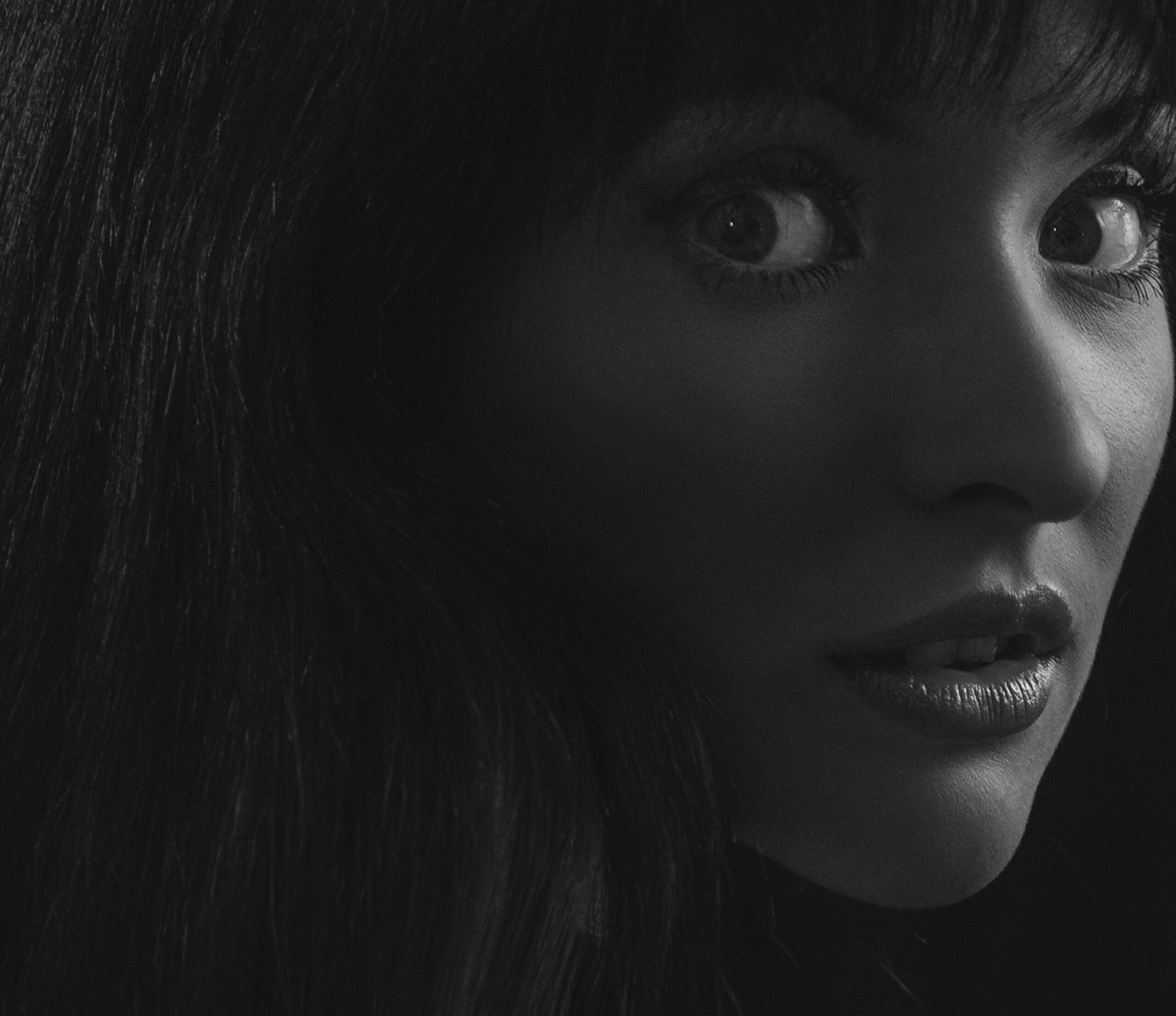 Close-up black and white portrait of a woman with expressive eyes and lips